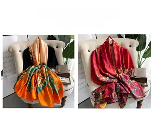 Detailed view of large printed silk scarves with vibrant vintage floral patterns
