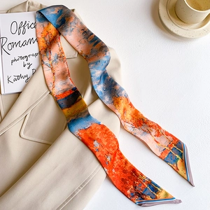 Close-up of abstract oil painting print silk scarf layered on a beige office blazer