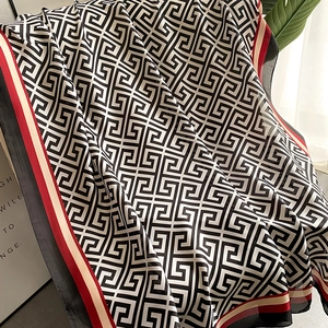 Detail of silk scarf showing black and white meander pattern and tri-color border