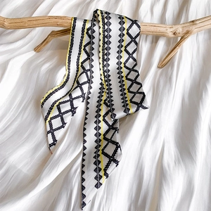 Detail of printed silk twilly showing geometric patterns on a smooth satin surface