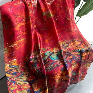 Macro detail of high-quality red floral print scarf with silk-like glossy texture