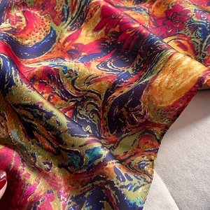 Macro detail of colorful floral print silk scarf with luxury satin texture and smooth seams