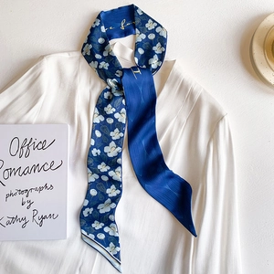 Elegant navy blue floral silk scarf styled on a white shirt with an office aesthetic