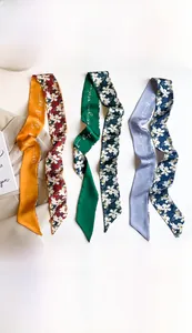 Detailed view of floral faux silk skinny scarves in yellow, green, and blue, 7x130cm size