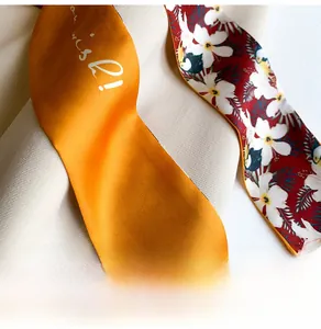 Detail of silk scarf showing yellow Wish text side and red toucan floral pattern