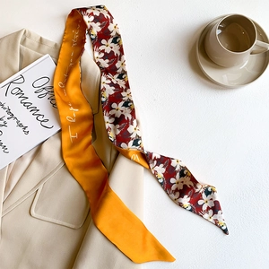 Detailed shot of a French-style silk scarf draped on a beige blazer with tropical prints