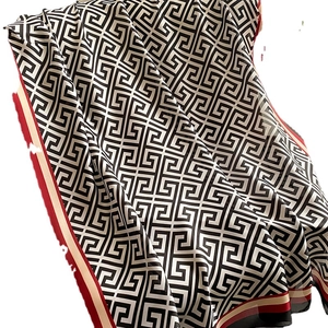 Elegant beach shawl with black and white Greek Key patterns and red striped edges