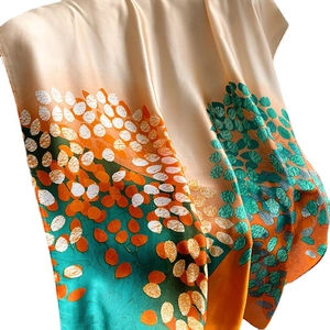 Elegant silk scarf with artistic leaf patterns in champagne gold and orange for women