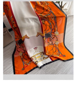 Detail view of vintage horse chain pattern silk scarf on elegant light wood floor