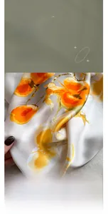 Detail of silk-like cotton scarf featuring orange floral patterns and smooth texture
