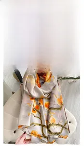 Detail view of long silk scarf with orange persimmon print on silver fabric