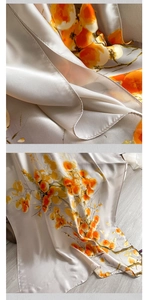 Detail of satin silk scarf with orange fruit patterns and delicate machine-rolled edges