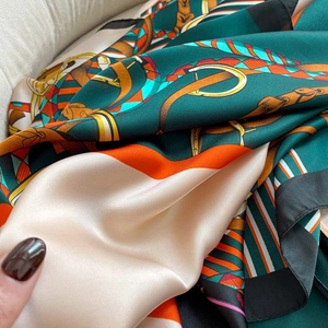 Luxurious equestrian print silk scarf with horse bit pattern in green and orange