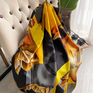 Vintage silk-like shawl with persimmon patterns and floral prints draped on a chair