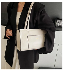 Minimalist cream white tote bag with long handles shown on model shoulder in professional shot