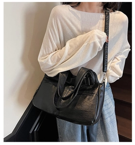 Detail view of large black tote bag featuring soft PU leather texture and adjustable strap