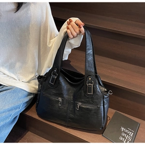 Détail du sac fourre-tout vintage en cuir noir avec deux poignées et fermetures argentées