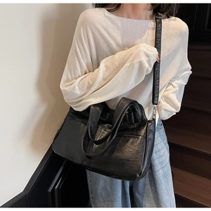 Détail du grand sac cabas noir en cuir texturé avec bandoulière réglable et poches