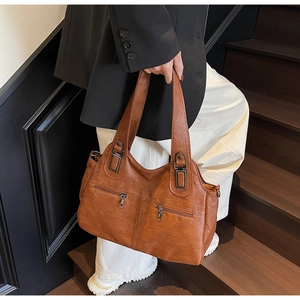 Vue détaillée du sac cabas marron en cuir texturé avec deux fermetures éclair en métal