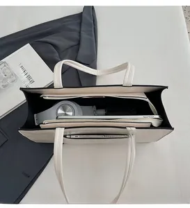 Top view of white tote bag interior showing spacious compartments for tablets and headphones