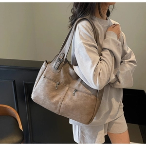 Détail d'un grand sac cabas vintage marron avec deux poches zippées et texture cuir