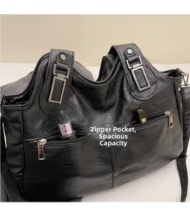 Detail van zwarte lederen tote bag met ruime ritszakken en grote interne opslagcapaciteit