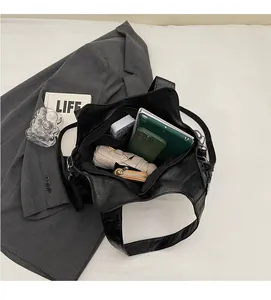 Detailoverzicht van het ruime interieur van de zwarte shopper met tablet en accessoires