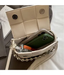 Macro shot of the off-white woven bag interior showing space for phones and cosmetics