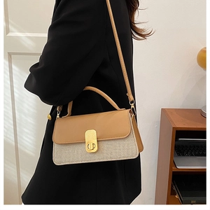 Detail der Damen-Umhängetasche in Farbkombination mit goldenem Drehverschluss am Model