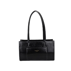 Minimalist black glossy leather tote bag with shoulder straps and gold logo lettering