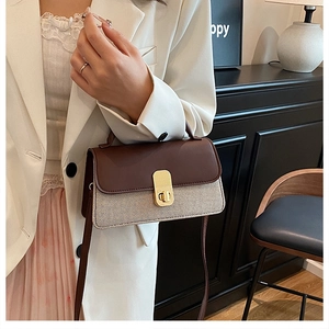 Détail du sac à main bicolore avec fermoir doré et rabat supérieur en cuir marron
