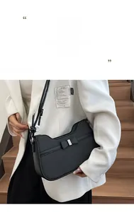 Détail du sac porté épaule tissé noir avec nœud en cuir et garniture métallique