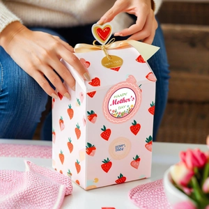 Pink strawberry pattern gift box for Mother's Day with golden ribbon and festive stickers