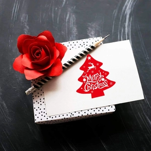 Christmas tree gift card with red tree design and polka dot box on dark wood background