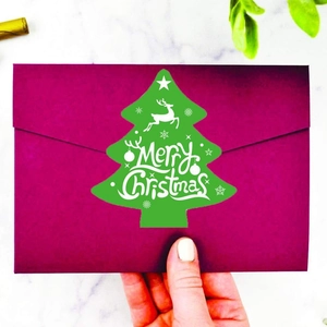 Green Christmas tree sticker with Merry Christmas text on a deep purple envelope