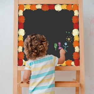Close-up of pumpkin bulletin board border stickers on a wooden classroom chalkboard