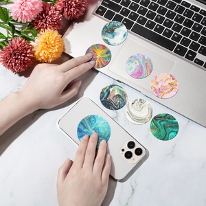 Macro detail of sensory anxiety relief stickers with marble texture on phone and laptop