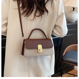 Sac bandoulière marron et beige avec fermoir en métal dans un décor de style moderne