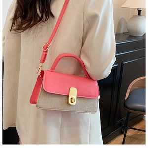 Détail du contraste entre cuir rose et tissu beige sur un sac à main tendance