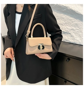 Close-up of beige crossbody bag featuring elegant metal buckle and smooth leather texture