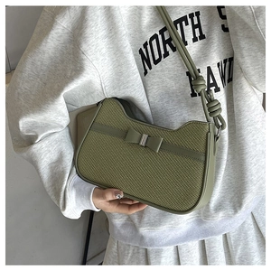 Détail d'un sac porté épaule vert matcha tressé avec nœud et bandoulière à nœuds