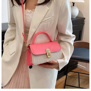 Detail of pink and beige crossbody bag featuring textured fabric and gold metal clasp