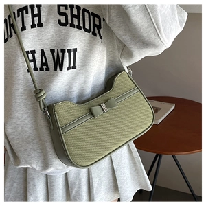 Détail du sac bandoulière tissé vert avec nœud et bandoulière en cuir ajustable