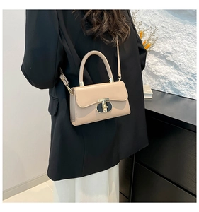 Beige faux leather crossbody bag with a curved handle and a unique gold-tone clasp