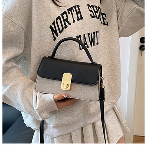 Détail du rabat en cuir noir et corps en tweed avec fermoir métallique doré sur le sac