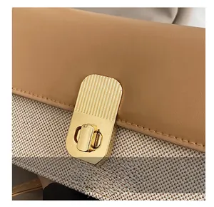 Detailansicht des goldenen Drehverschlusses und des kontrastierenden Webstoffs der Tasche
