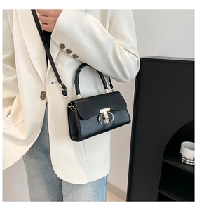 Detail of elegant black leather handbag featuring a golden double-ring metal buckle