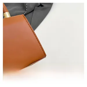 Close-up of premium brown leather handbag with contrast stitching and gold hardware
