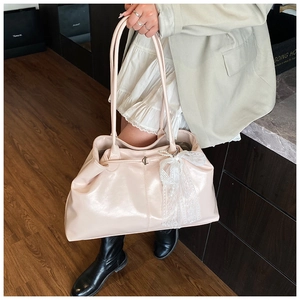 Detail of light pink glossy leather tote bag with elegant white lace bow charm