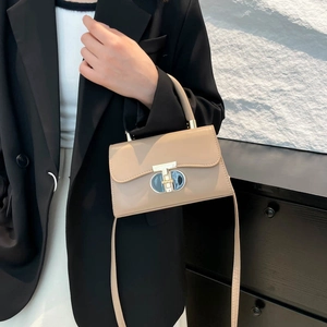 Beige leather crossbody bag with a distinctive T-lock metal clasp and top handle